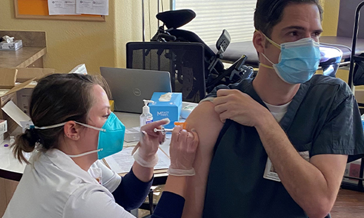 Male employee receiving COVID-19 vaccine shot
