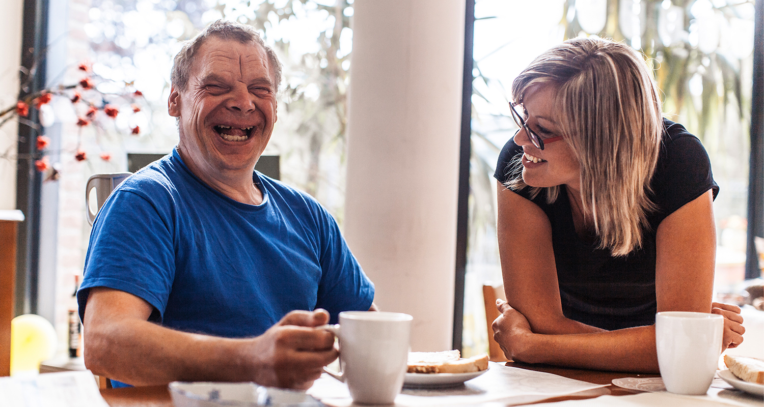 caregiver with man at table