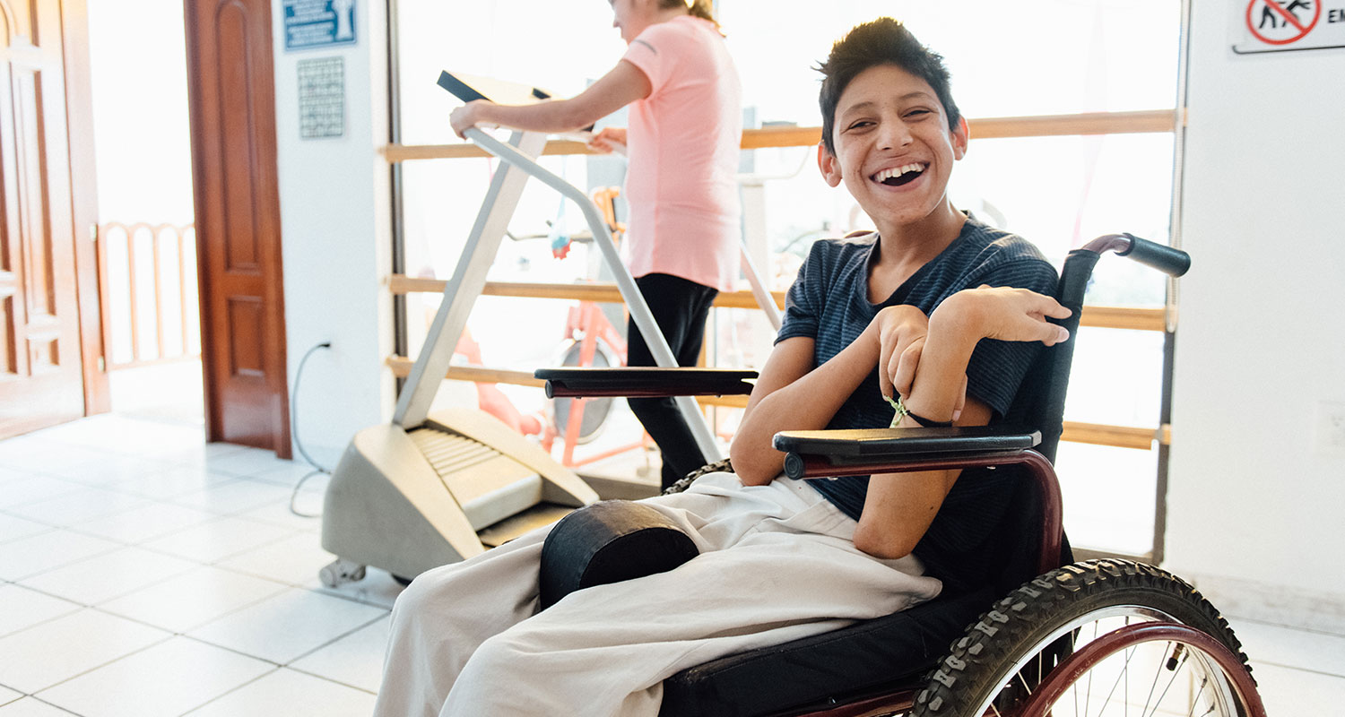Young man in a wheelchair smiling in the gym