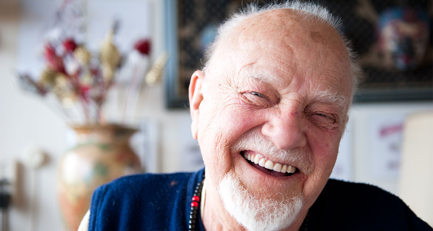 Male senior rehabilitation patient smiling in home