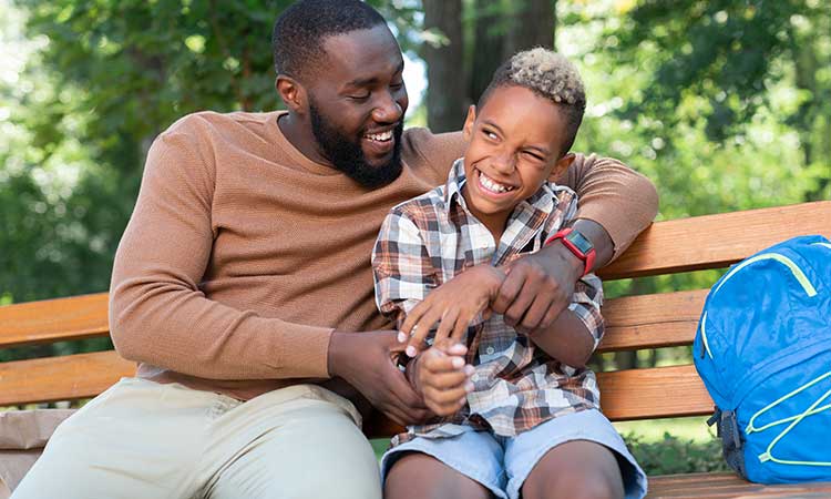 Father and son sitting on a bench and hugging