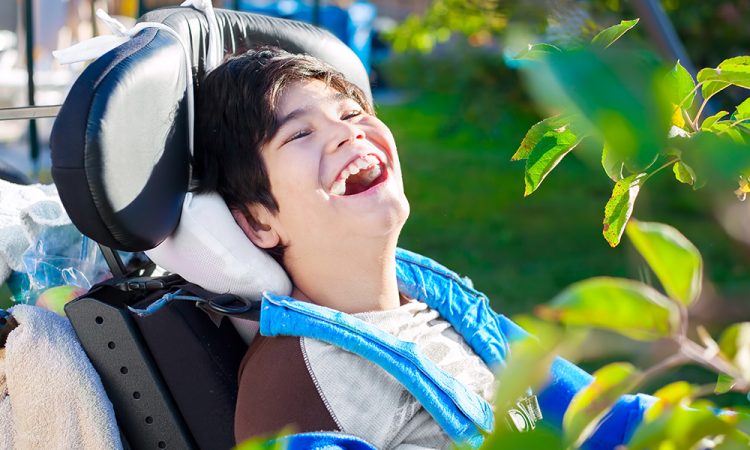 boy in wheelchair laughing outside