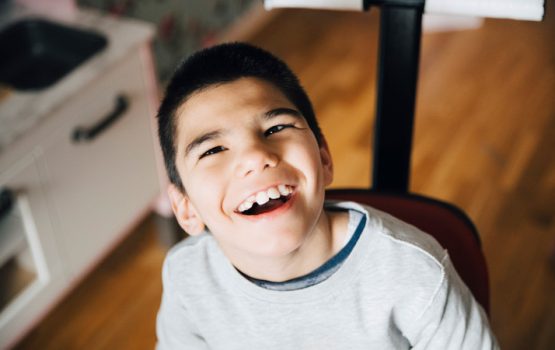 boy with autism sitting and smiling