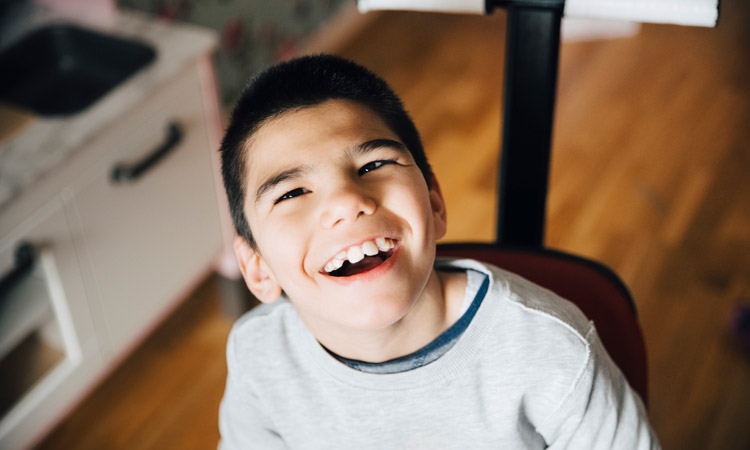 boy with autism sitting and smiling