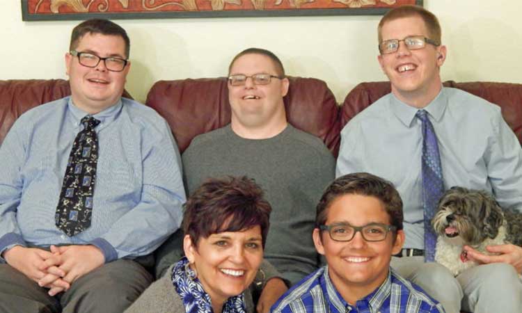 Host home Mentor with her two sons and two young men she supports sitting together on the couch