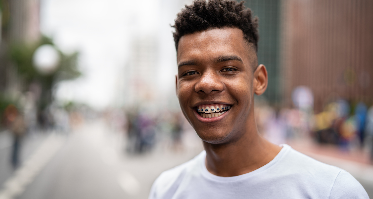 Young african-american man smiling outside in city
