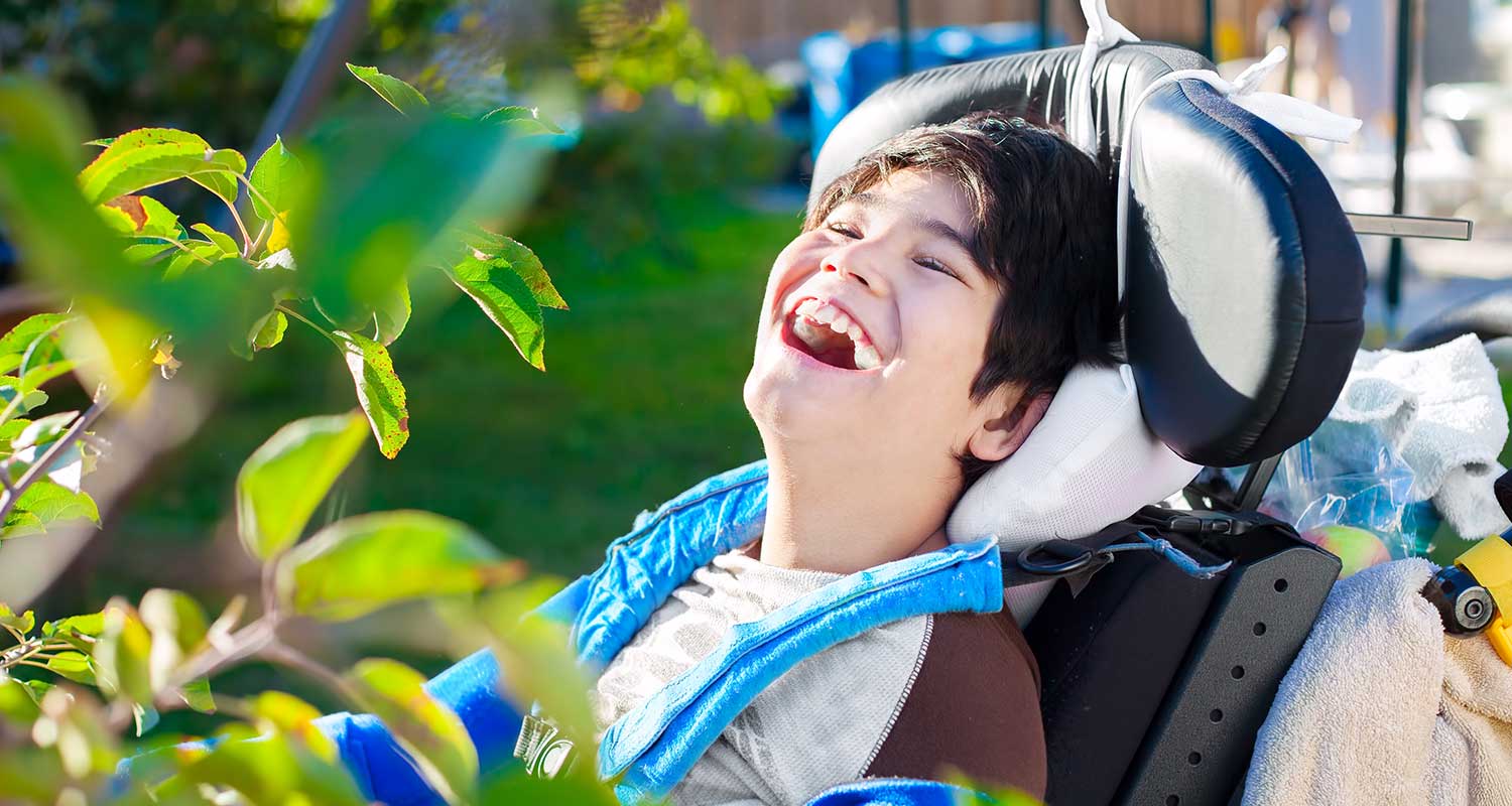 boy in wheelchair laughing outside