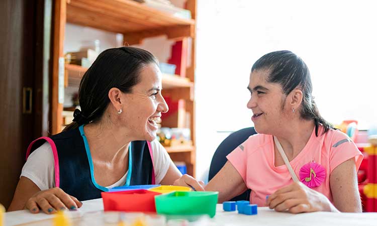 young woman with developmental disability with female staff member at day program