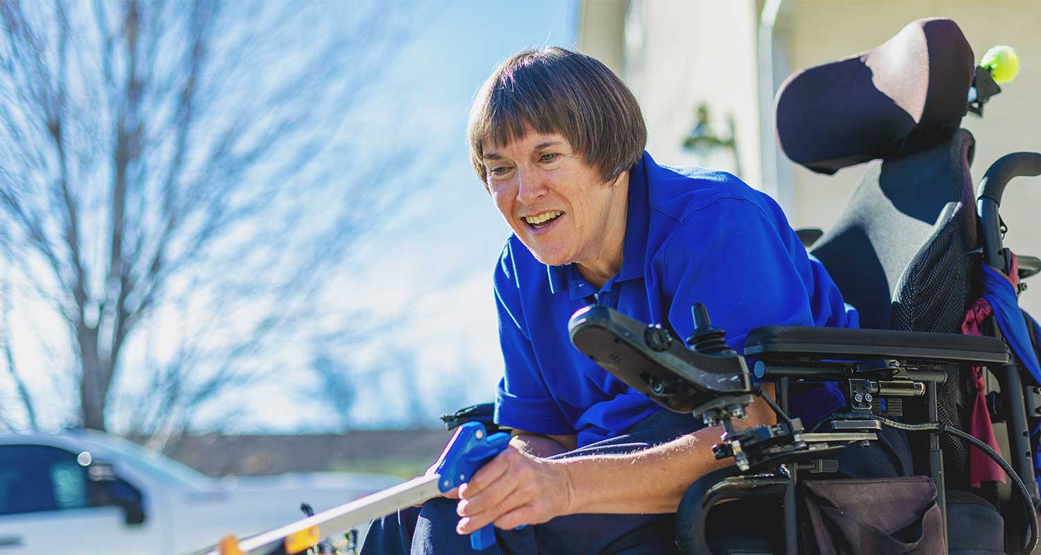 Woman in wheelchair smiling outside
