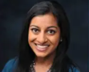 Dr. Zarina Norton is a woman with dark hair and is smiling at the camera.