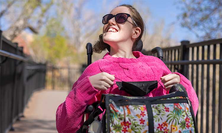 Woman in wheelchair outside and smiling
