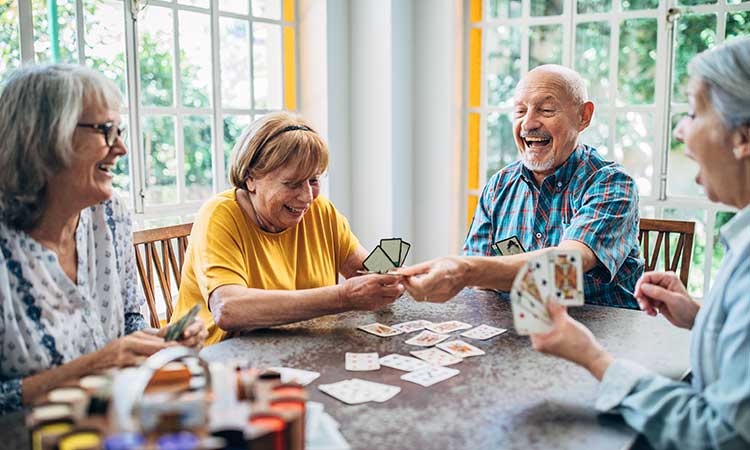 senior man and women playing cards and laughing