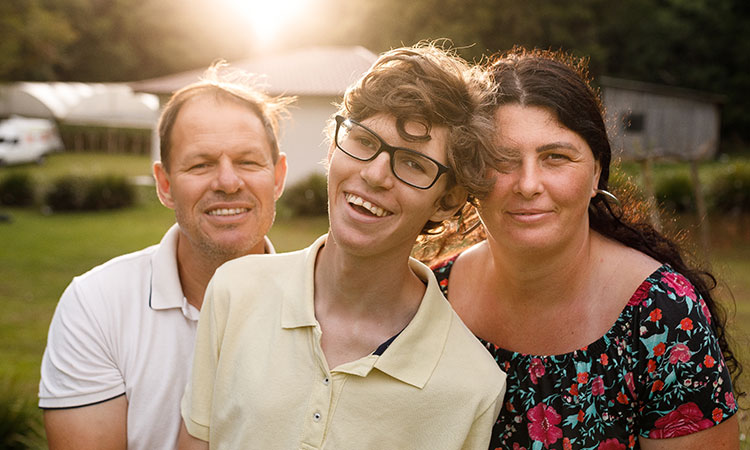 Young adult man with his parents in their yard