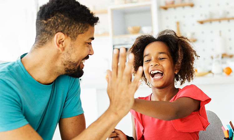 Girl and her father high-fiving each other